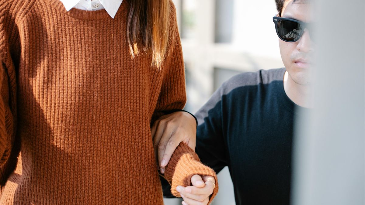 Support worker steadying a participant's arm while walking outdoors